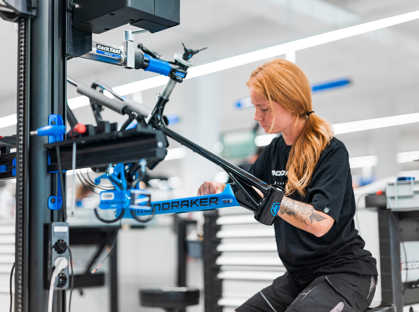 Stealth Alloy Rahmen Modell Crafty_fortschrittlichste Technologie für Industriedesign und Strukturoptimierung im Mondraker Sortiment_Fahrradrahmen Handwerkskunst Produktionsmitarbeiterin von Mondraker baut grade ein brandneues EMTB Crafty am Montageständer auf mit Stealth Alloy Rahmentechnologie